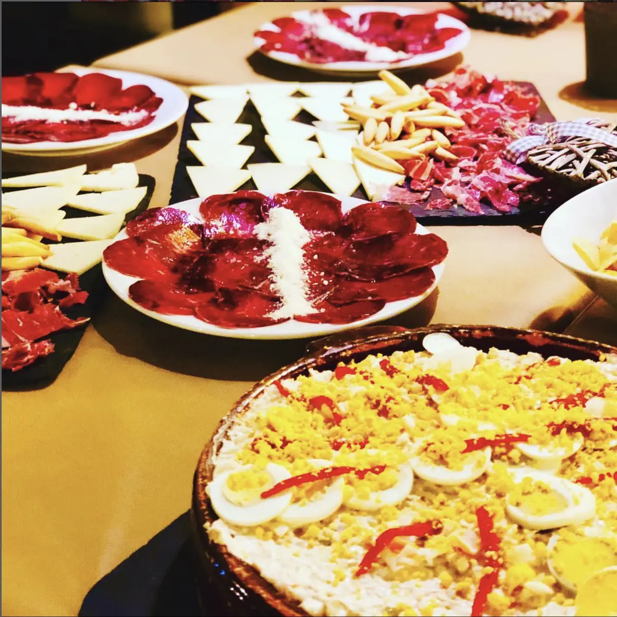 Mesa con entrantes: embutidos, quesos y ensaladilla