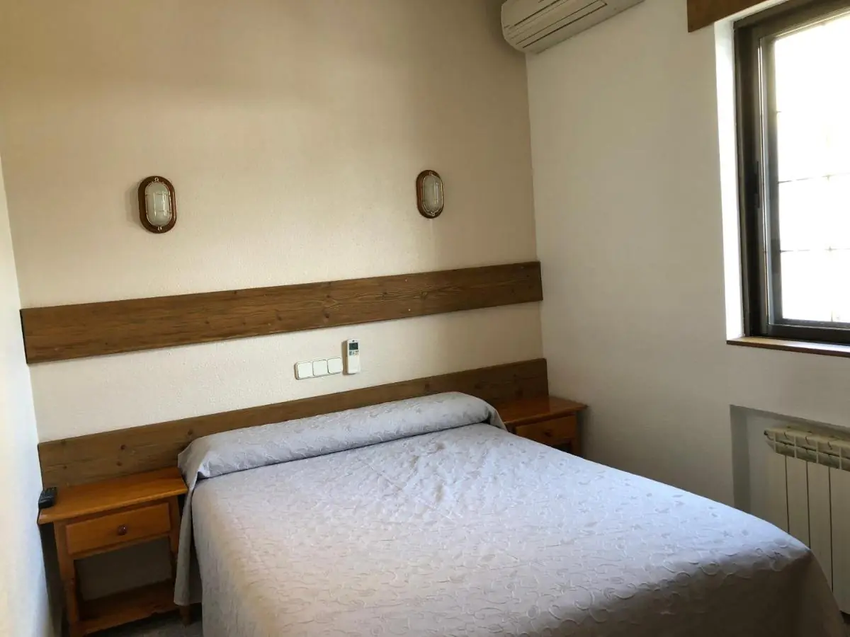 Habitación doble con cama de matrimonio, ventana y aire acondicionado