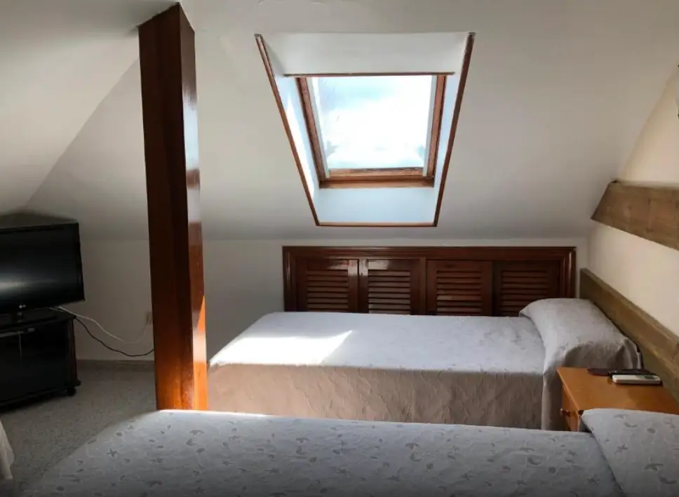 Habitación triple abuhardillada con tres camas individuales